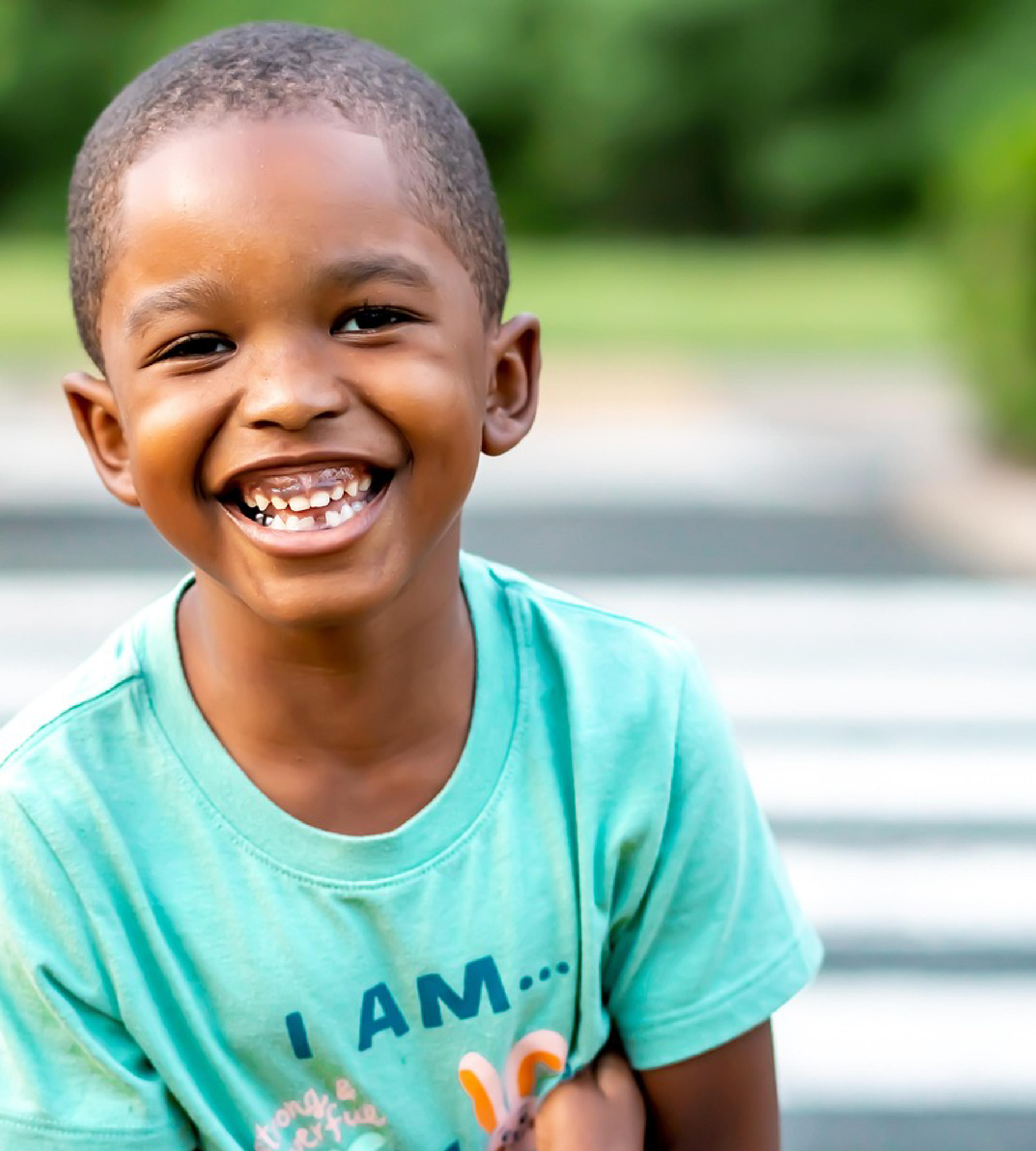 Young African American boy smiling at a cross walk.